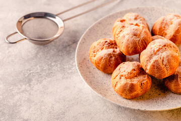 Homemade profiteroles with powdered sugar.