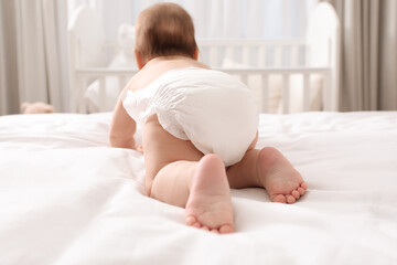 Little baby in diaper on bed at home, back view - obrazy, fototapety, plakaty