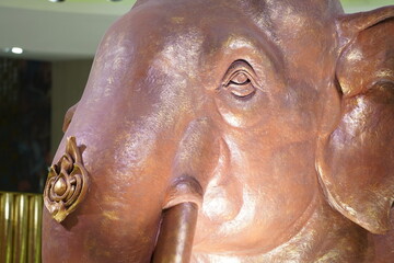 Elephant head statue copper color close up.