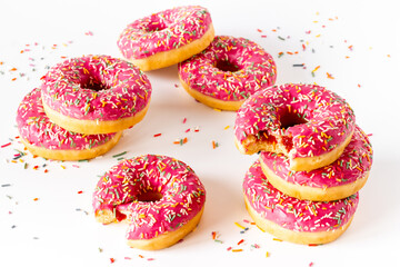 Sweet snacks - pink frosted donuts with colorful sprinkles
