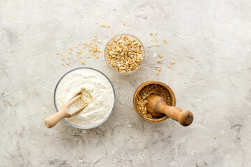 Pestle oat flour - grains with mortar on kitchen table