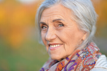 Portrait of happy senior woman in autumn park