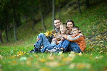 Portrait of family of four sitting in park