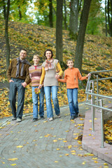 Family of four walking in autumn park