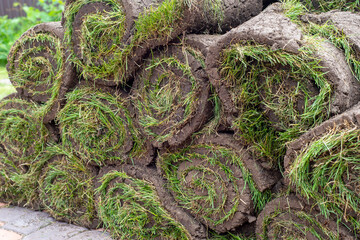 stacks of sod rolls for new lawn