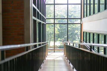 wooden slope walkway in the library with the window light from outside.