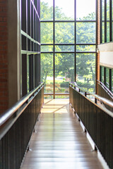 wooden slope walkway in the library with the window light from outside.