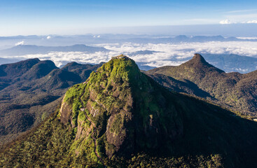 Adam's Peak is a 2243 m tall conical mountain located in central Sri Lanka - Sacred Mountain for four religions with a temple on the top. Aerial flying drone shot. - obrazy, fototapety, plakaty