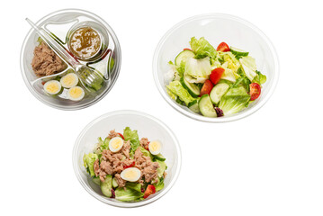 Fresh tuna salad with lettuce, cucombers, cherries and eggs in plastic container.