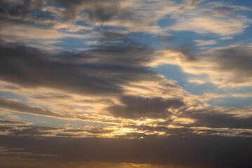 Wonderful view of cumulus clouds sky with orange sun light at sunset of summer
