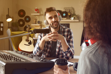 Man interviewing young woman in modern radio studio