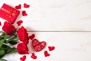 Red roses and hearts on a white wooden background. Valentine's day, place for text.