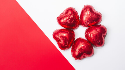 Stylized top view for Valentine's Day on a white background. Red chocolate hearts on blank paper. holiday concept.