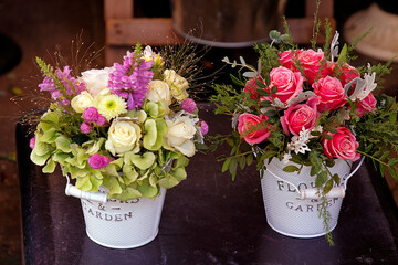 Rose flowers in metal buckets