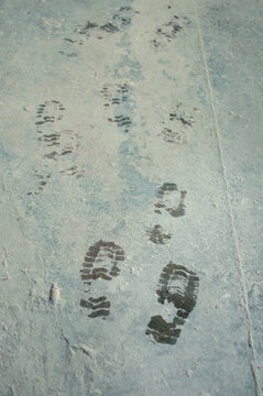wet bootprints on dirty concrete floor in vertical format