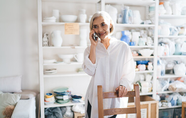 Business woman talking on smartphone at art studio