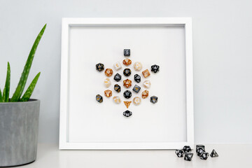 A framed piece of art: a mandala made from polyhredral dice. Mandalas are a symbol of the universe,...