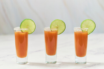 Three tequila shots with sangrita and lime on top. Mexican appetizer for tequila.