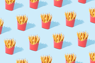 French fries in red box pattern on pastel blue background. Pattern with yellow pencils in box for french fries potatoes. Potatoes inspiration. Flat lay minimal concept. Beggining of school.