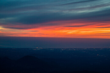 Twilight to Night from the jet plane view red orange blue sky with the light of Thailand city below