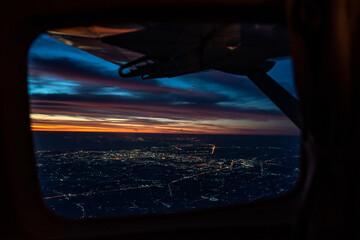 Twilight to Night from the jet plane view red orange blue sky with the light of Thailand city below