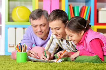 Portrait of happy father and his children drawing