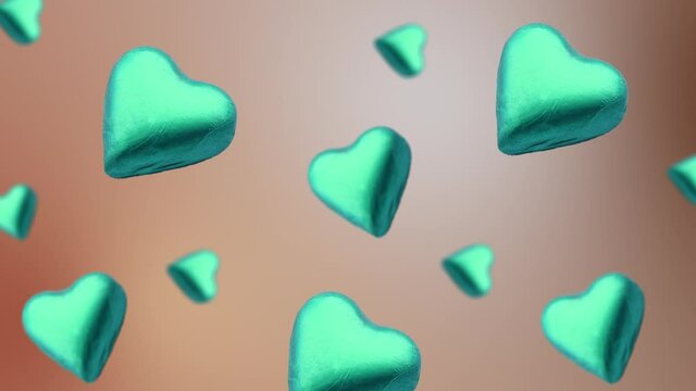 A heart shape wrapped chocolate candy flying and wiggle on a trending turquois color, on the natural beige background. Sweet food concept. Love template for mother's and valentine's day. 4k template