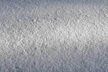 A ray of light at dusk on a flat snowy surface. Snow pattern and texture.