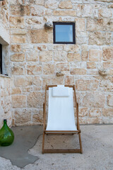 Glimpses of a white deck chair on the outdoor veranda of renovated and refurbished typical stone...