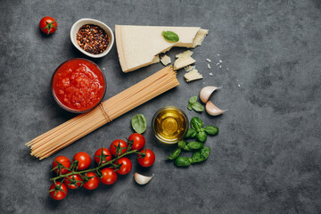 Fototapeta na wymiar Italian food pasta spaghetti, parmesan cheese, olive oil, spices, basil, tomato sauce and fresh tomatoes. top view
