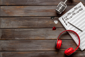 Compose music concept with music sheets and headphones, top view