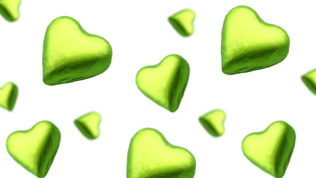 A stream of many different diameters heart shape wrapped colorfulchocolate  candy flying on a white color background.Romantic template Love concept for mother's, St. Valentine's and women's  Day