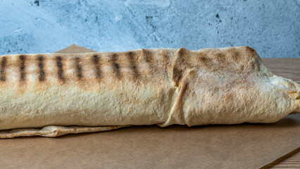 Shawarma chicken roll. Fresh roll of thin lavash or pita bread filled with grilled meat, cheese, carrots, sauce, green.