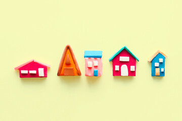 rustic multi-colored cute houses and plasticine on a yellow background..