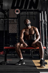 Plakat Dark-skinned African American Man Sit Having Rest, Relaxed After Intense Cross Fit Training In Gym, Healthy Lifestyle And Sport Concept. Fitness, Sport, Workout.