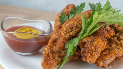 Breaded chicken strips with sauce on white plate. Crispy fried chicken tenders. Fast food on white plate background.