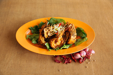 Spicy Black Pepper Crayfish with raw onion and red chili isolated on wooden background top view