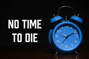 No time to die word with alarm clock in dark mode. Motivation and depression concept