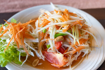 Papaya salad, Thai style salad with papaya fruits. Thailand cuisine photo close-up with selective focus