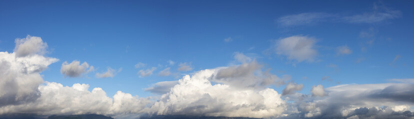 Panoramic View of Cloudscape during a cloudy blue sky sunny day. Taken on the West Coast of British Columbia, Canada.