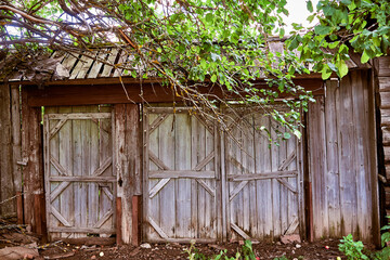 Wooden gates of an old abandoned house. Traditional Russian village architecture.