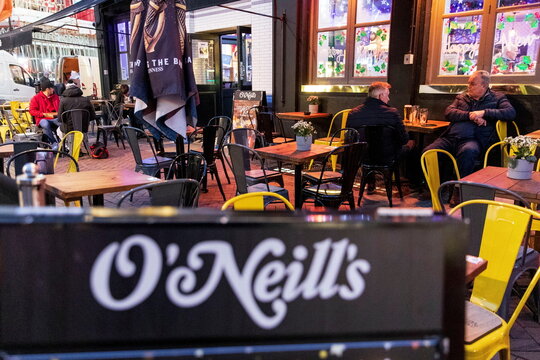 Patrons sit outside an O'Neill's pub in London