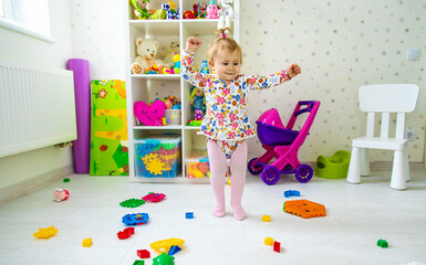 The child plays with toys in the room. Selective focus.