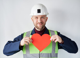 Cute caucasian bearded construction supervisor, contractor or engineer standing by the wall holding...