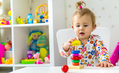 The child plays with toys in the room. Selective focus.