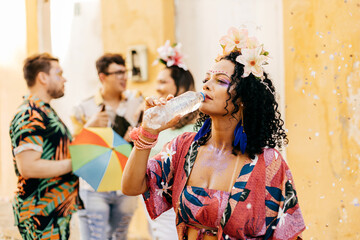 Brazilian Carnival. Woman drinking water during carnival block on the street