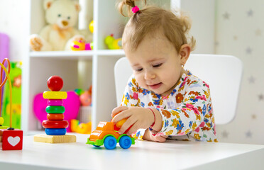 The child plays with toys in the room. Selective focus.