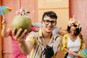 Brazilian Carnival. Concept of care during carnival. Person hydrating himself by drinking coconut...