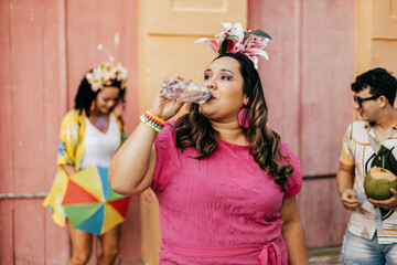 Brazilian Carnival. Person drinking water during carnival block on the street