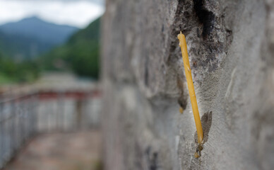 Candle on a stone wall. The wall of the temple. Prayer for peace.